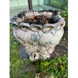 A glazed ceramic planter with platted design around the top and natural scene including a clock in a