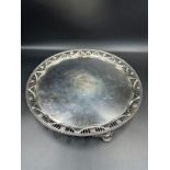 A George III silver salver on three feet with pierced decorative design of flowers and swags to edge