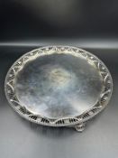 A George III silver salver on three feet with pierced decorative design of flowers and swags to edge
