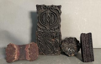Four vintage carved wooden printing blocks in various decorative patterns