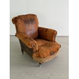 An antique leather club chair in a distresses manner (H84cm W87cm D79cm SH32cm