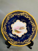 A selection of five early 20th century Coalport hand painted plates with blue grounds, under an acid