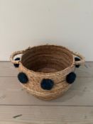 A wove rush basket with pom poms (H32cm W59cm)