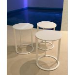 Three white circular side tables