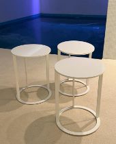 Three white circular side tables