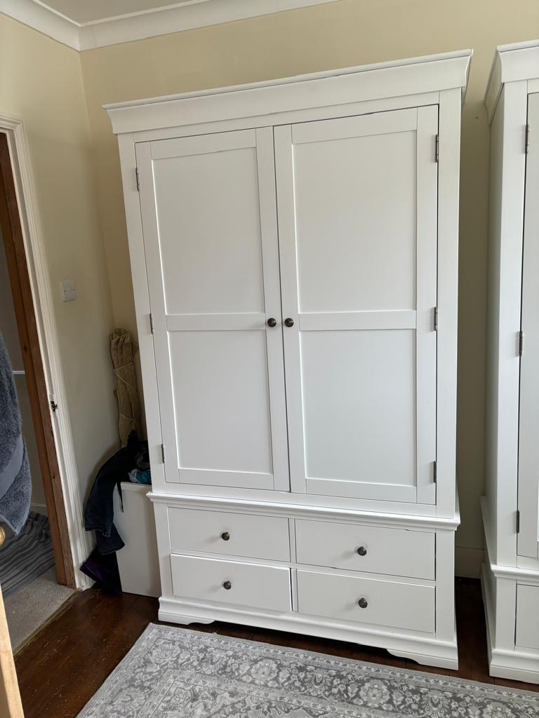 A white two door wardrobe with four drawers below and hanging space above (H200cm W114cm D55cm)