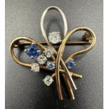 A diamond and sapphire spray brooch on yelllow and white gold with an approximate total weight of