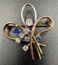 A diamond and sapphire spray brooch on yelllow and white gold with an approximate total weight of
