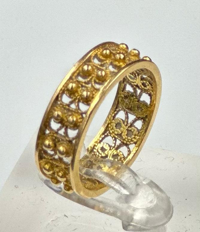 An Arabian gold band ring with filigree decoration, approximate total weight 4g. Size P