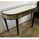 A mirrored console table on tapering legs (H77cm W110cm D35cm)