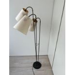 A three arm floor lamp, brass and black enamelled stem with articulated three arm lamps possibly