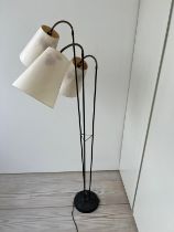 A three arm floor lamp, brass and black enamelled stem with articulated three arm lamps possibly