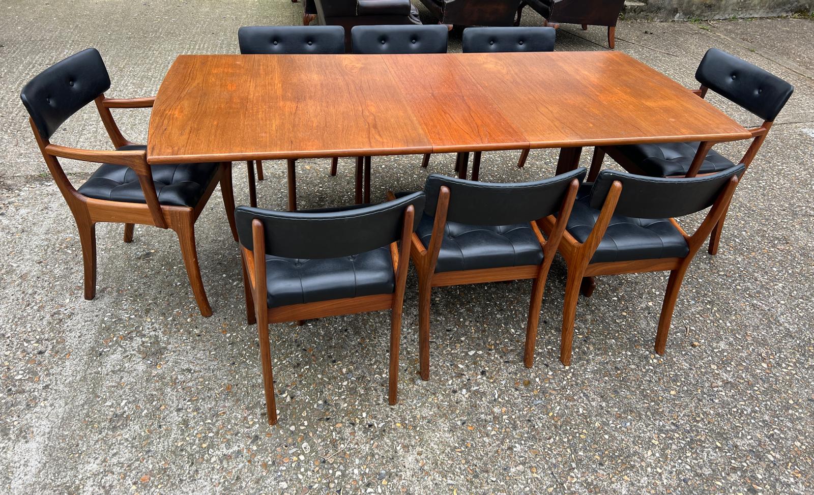 An extending teak dining table by Vanson along with the Vanson for Heals eight chairs whit black