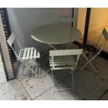 A metal bistro set comprising of a table and four folding chairs (H74cm Dia97cm)