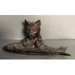 A bronze of a cat holding a fish possibly a pin tray or trinket dish