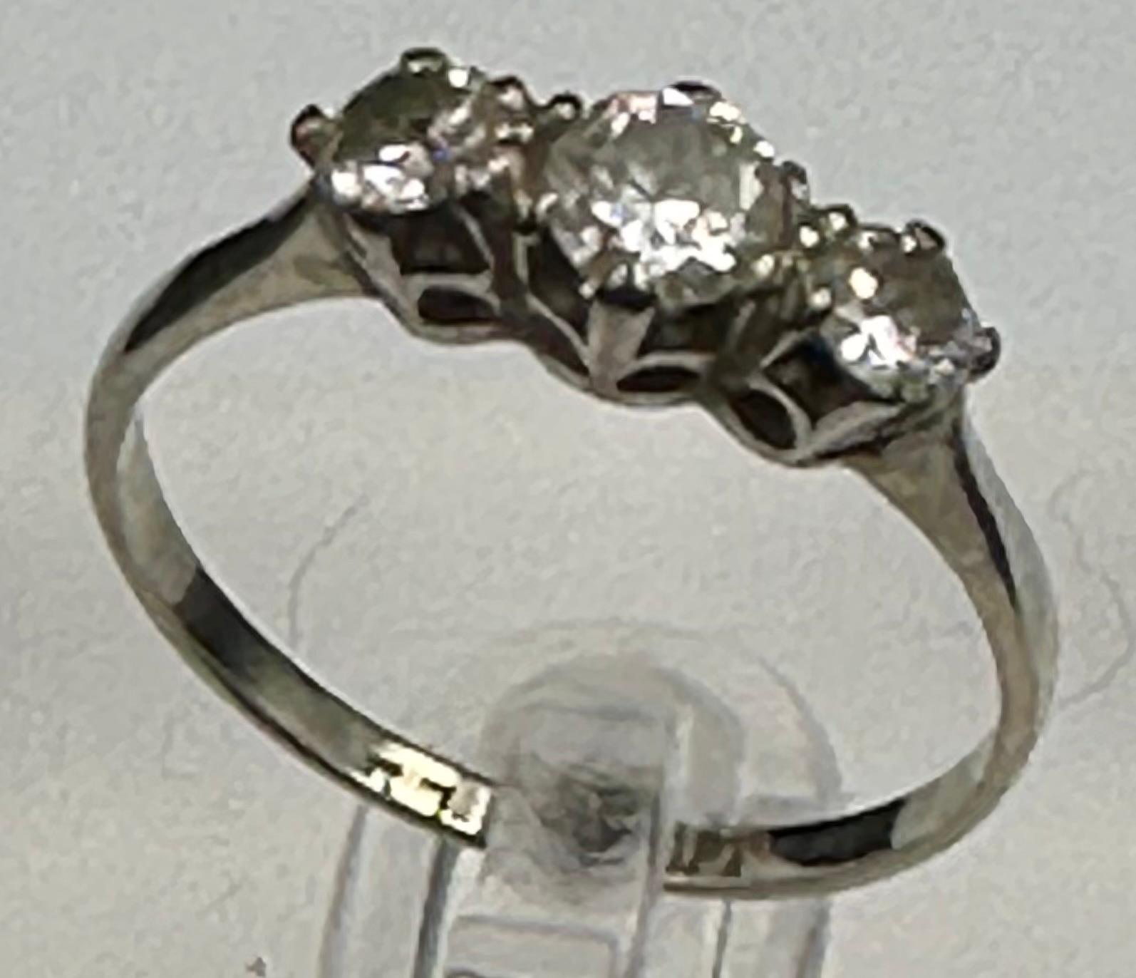 A three stone diamond ring on 18ct white gold and platinum set Size N
