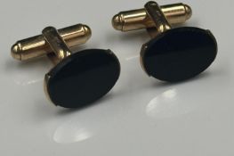 A pair of onyx on 9ct yellow gold cuff links with an approximate weight of 7g