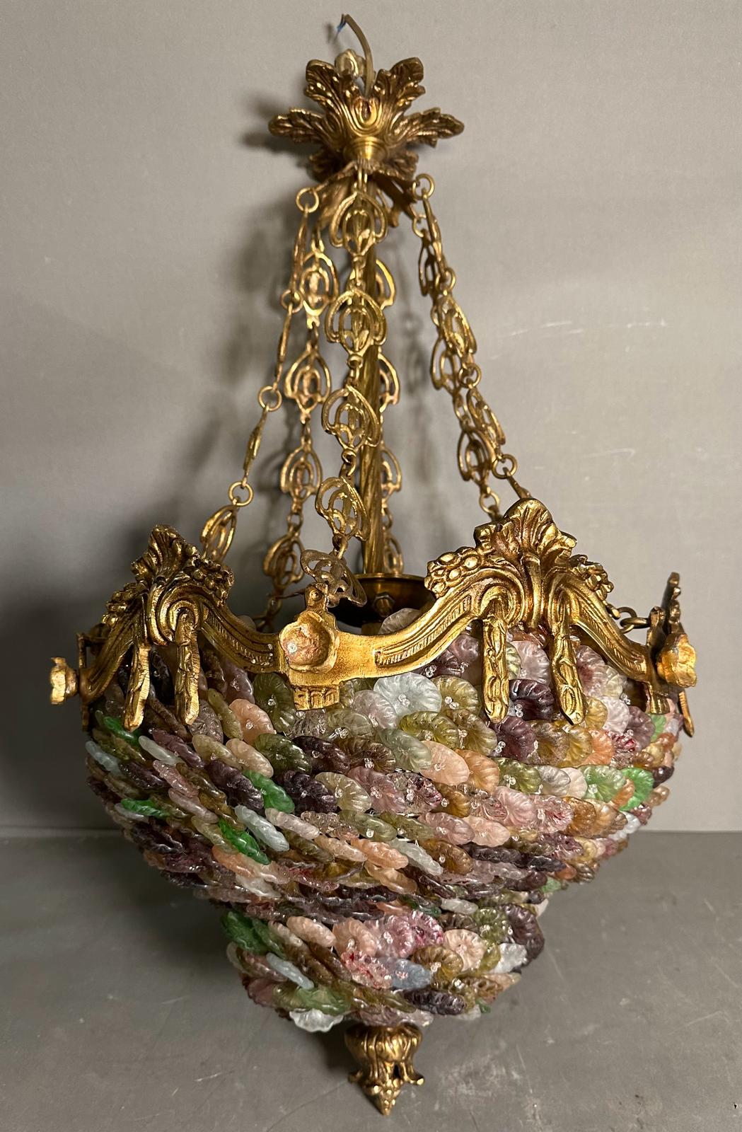 A Murano gilt brass and coloured glass chandelier in pinks, greens and purple.