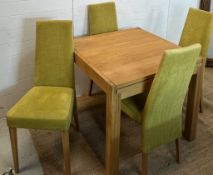 A light oak dining table and four lime green chairs (H75cm Sq85cm)