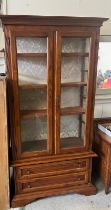 A glass display Gun cabinet with two long drawers to base (H190cm W102cm D38cm)