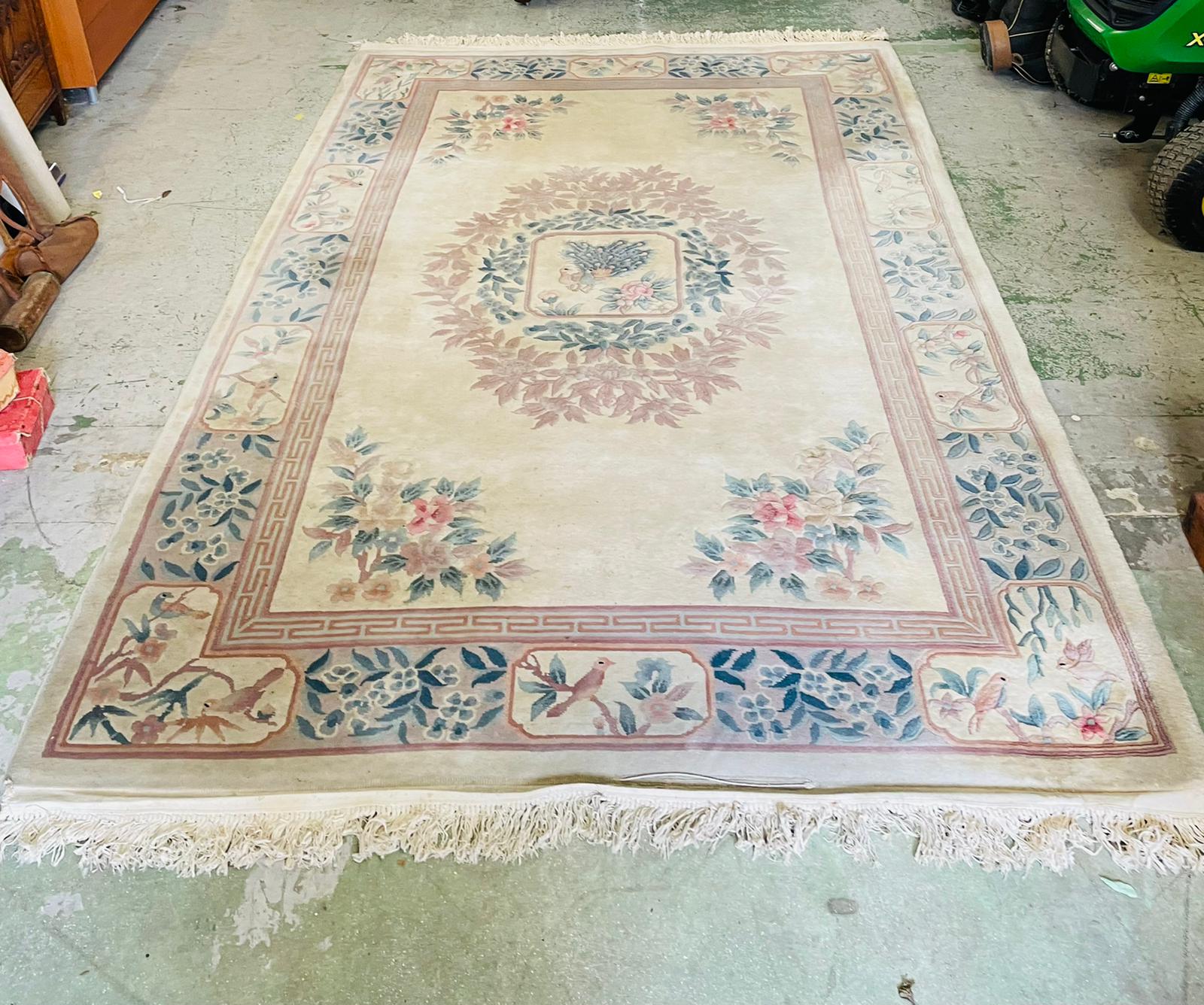 A wool rug with white grounds and central flower shield and geometric boarder (186cm x 280cm)