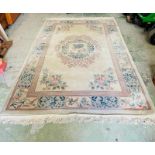 A wool rug with white grounds and central flower shield and geometric boarder (186cm x 280cm)