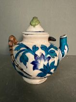 A small Chinese style teapot with a blue leaf design, snake handle and a decorative frog finial to