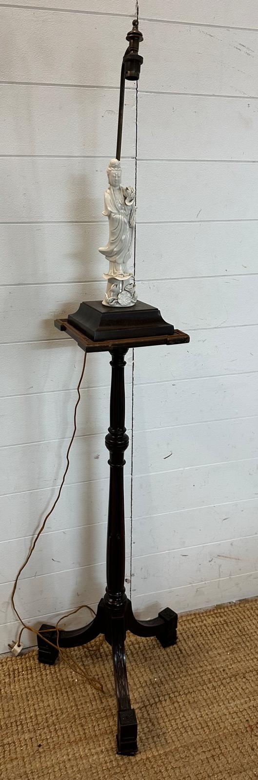 A floor standing pedestal lamp on splayed tripod legs, fluted central column and white ceramic