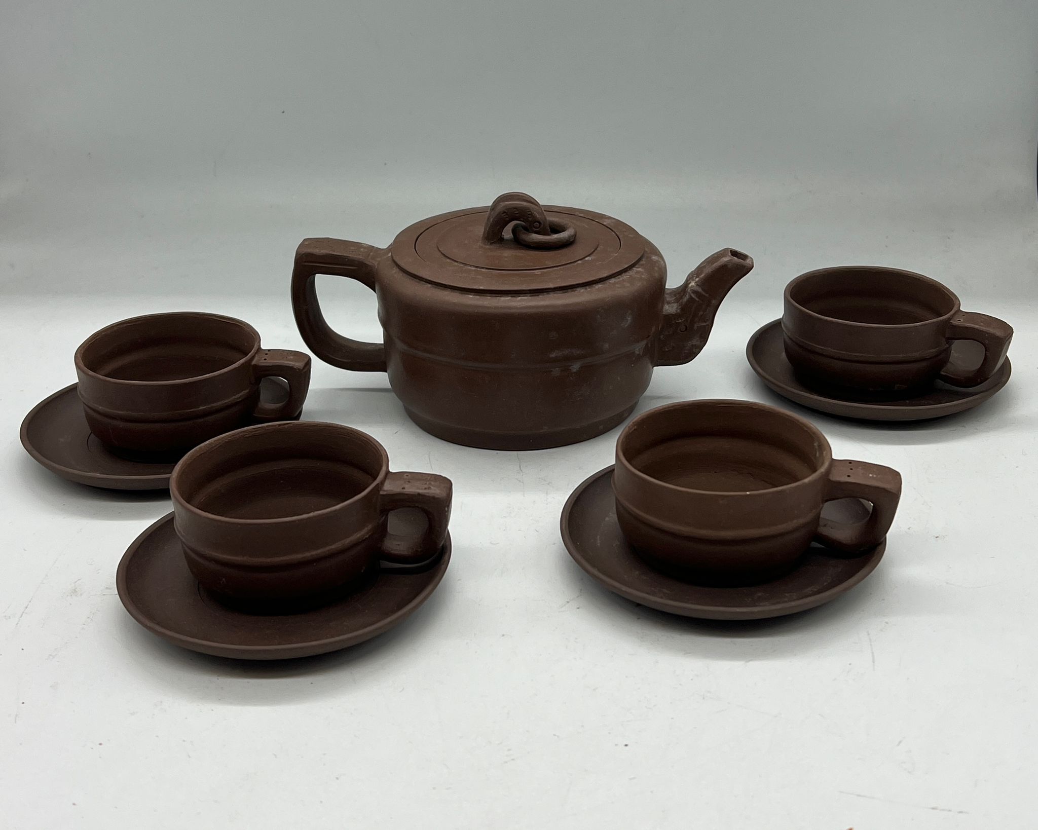 A Chinese clay tea set comprising of four cups and saucers and one teapot