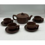 A Chinese clay tea set comprising of four cups and saucers and one teapot