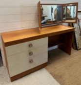 A contemporary three drawer dressing table with bifold vanity mirror on chrome supports (H69cm