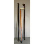 A selection of three walking sticks, one with a silver top and another with a silver collar.