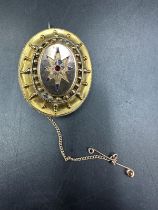 A Victorian decorative morning brooch with central star and glass to back