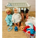 A vintage white wooden children's toy doll cot with dolls, bedding and toys
