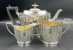 A three piece silver tea service by Lee & Wigfull with a semi fluted design hallmarked for Sheffield