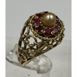 An Arabian gold cocktail ring with ruby and central pearl, approximate total weight 6.7g.