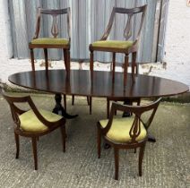 An oval dining table on twin pedestal and castors with six stylish curved chairs