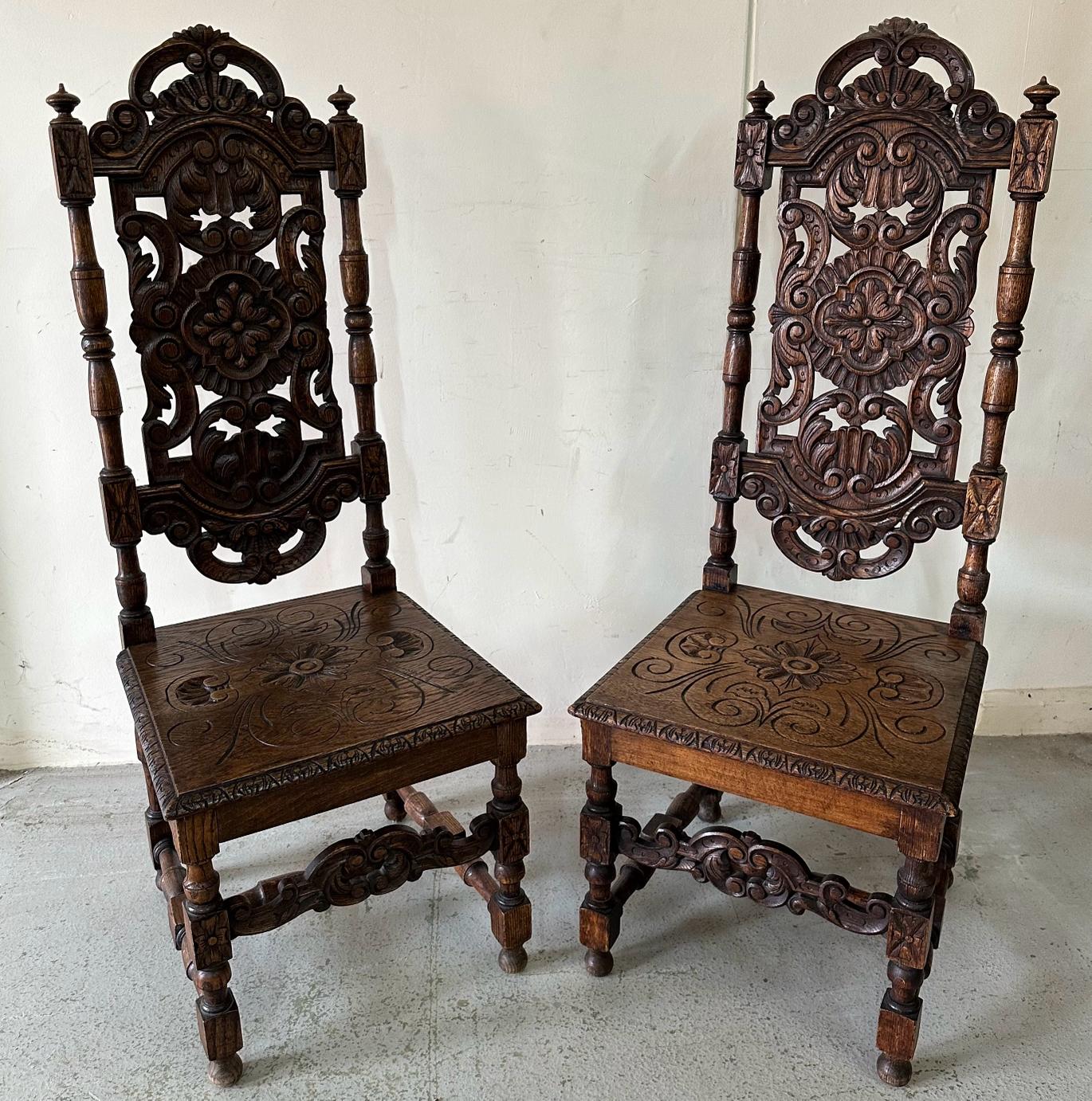 A pair of Victorian style oak hall chairs with carved seats and back, turned supports ending in