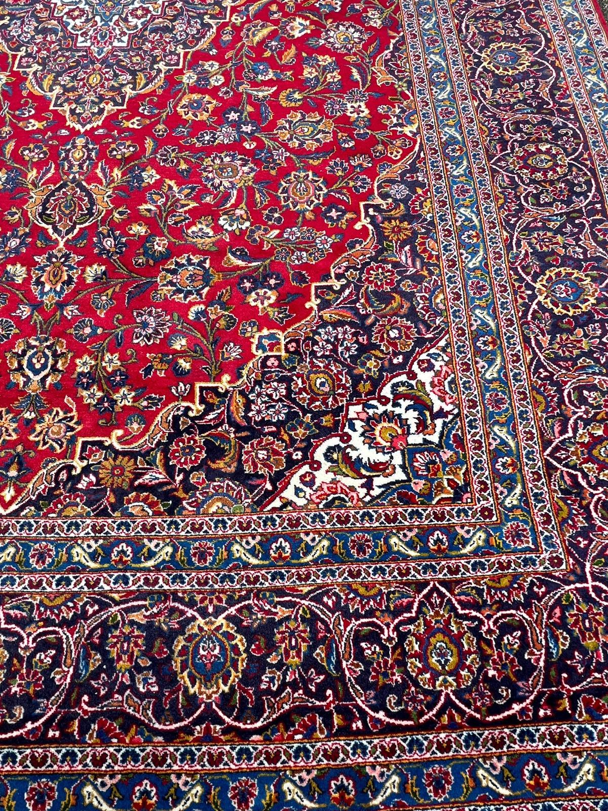 A hand knotted wool Kashan rug, rich red background with central medallion and elaborate - Image 3 of 8