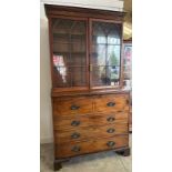 A Georgian mahogany secretaire bookcase, glazed doors opening to shelves, the base fitted with