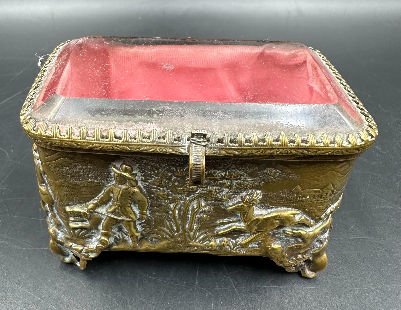 An antique French, bevelled edge glass topped jewellery box with hunting scene decoration.