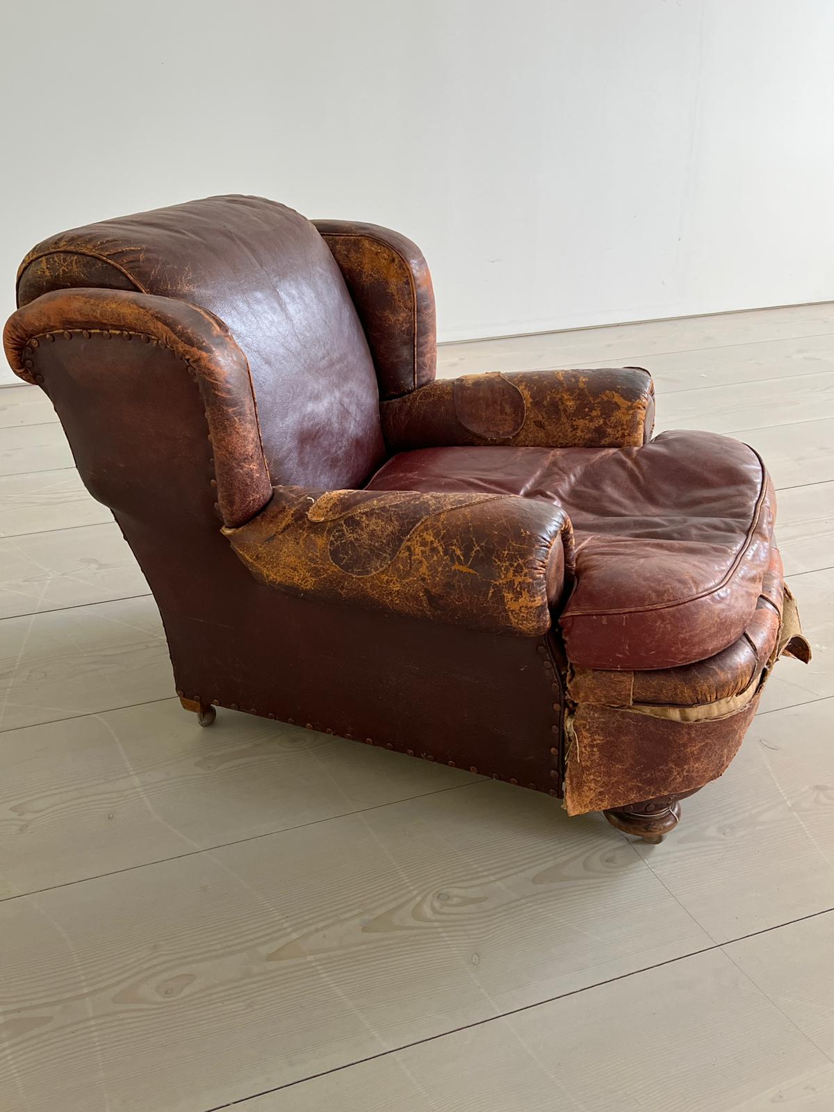 An antique leather club chair in a distressed manner (H84cm W97cm SH37cm) - Image 4 of 7