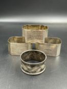 A selection of four silver napkin rings with various hallmarks and a combined weight of