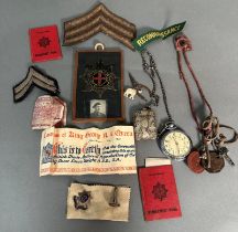 A selection of WWII ephemera, cap badges, whistle, insignia, pocket watch etc.