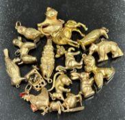 A selection of fifteen 9ct gold charms featuring a wide variety of characters with a combined
