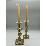 A pair of brass candlesticks with glass finials