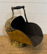 A vintage brass coal scuttle with an arts and crafts repousee pattern
