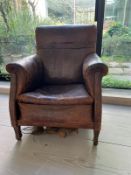 An antique leather club chair in distressed manner with scrolling arms (H95cm W71cm D31cm SH43cm)