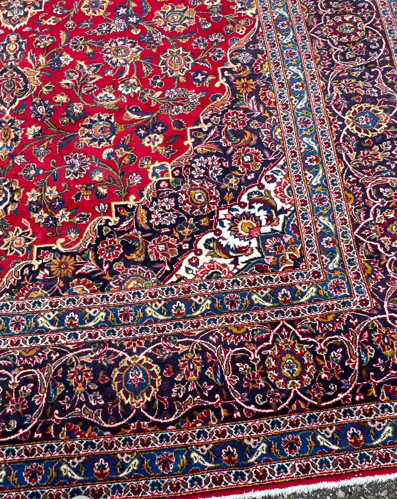 A hand knotted wool Kashan rug, rich red background with central medallion and elaborate - Image 8 of 8