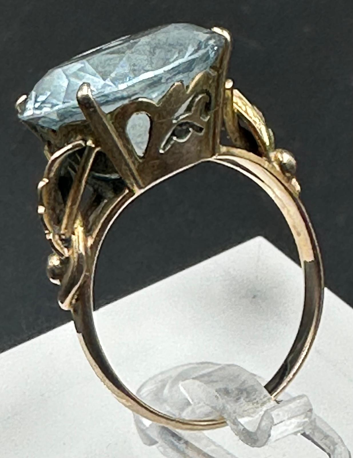 A 14ct aquamarine ring with floral motif shoulders, approximate total weight 4.4g. Size M